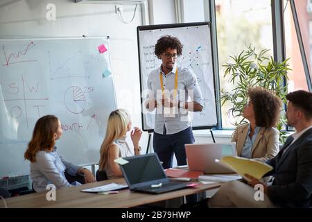 Business team and manager in meeting room. young business man afro-american explaining  analysis at the meeting. Stock Photo