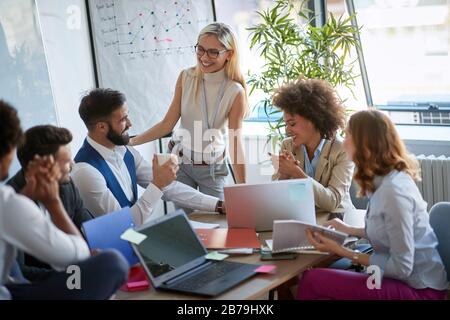 Creative professionals working.Smiling business people   working together as team and discussing ideas at briefing in office. Stock Photo