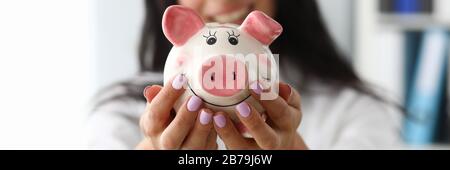 Smiling woman with piggy bank Stock Photo