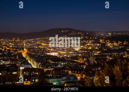 Germany, Magical aerial view above illuminated skyline of city stuttgart houses in basin in clear winter night with starry sky and lots of lights Stock Photo