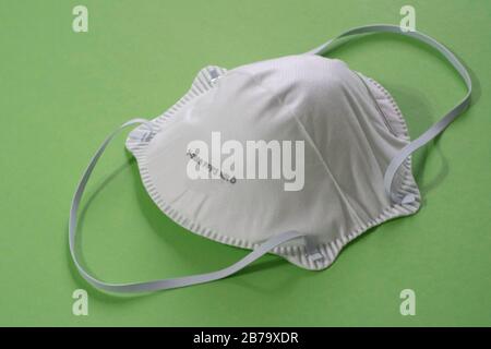 Surgical mask with rubber ear straps. FFFP2 green background Stock Photo