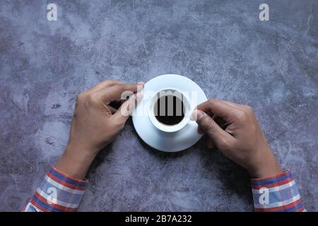 top view of man hand drinking tea on black tiles  Stock Photo