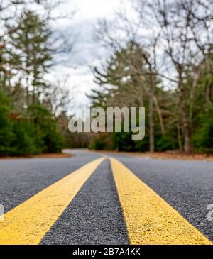 close up image of a double yellow on a paved road in East Hampton, NY Stock Photo