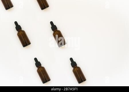 Natural cosmetics glass bottles pattern. Medicine concept. Jars with essential oil isolated on white background. Flat lay or top view.