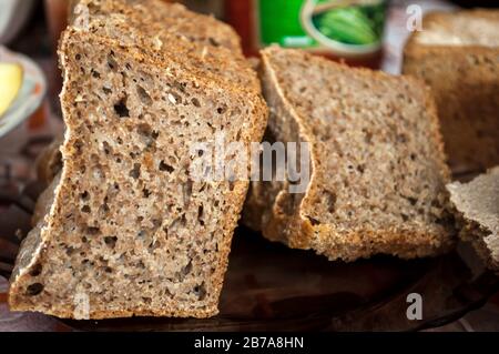 sliced slices of natural bran bread on a transparent glass plate Stock Photo