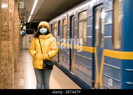 The young europeans woman in protective disposable medical face mask in the subway. New coronavirus (COVID-19). Concept of health care during an epide Stock Photo