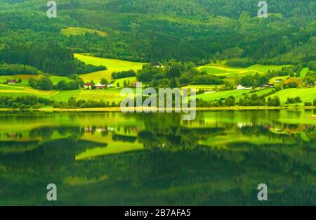 Picturesque view of lake on summer gloomy rainy day ,lakeside reflection on water.Vangsvatnet lake in the municipality of Voss,Vestland county, Norway Stock Photo