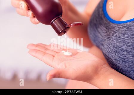 Pregnant woman applying body lotion on the hand. Stock Photo