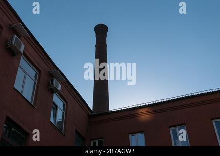 A fragment of an old brick factory building with a pipe. Stock Photo