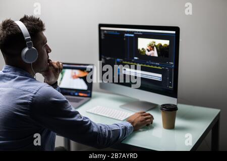back view of video editor using computer Stock Photo