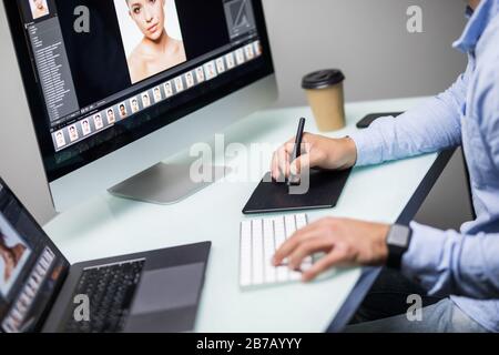 Hand of male designer work at his desk using stylus and digital graphics tablet. Stock Photo