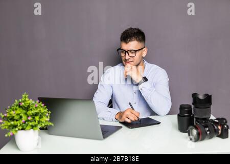 Young handsome man photo editor using graphics tablet in a bright office Stock Photo