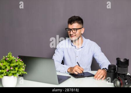 Young handsome man photo editor using graphics tablet in a bright office Stock Photo