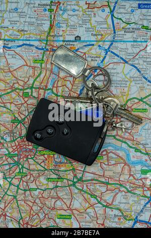 A set of keys and a car key laid on top of a road map of London Stock Photo