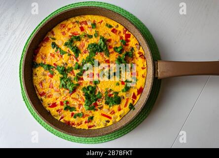 Juicy and tasty omelette with tomatoes and cheese on a pan Stock Photo