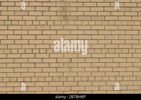 Photo of a grunge tan brick wall taken outdoors on a sunny day Stock Photo
