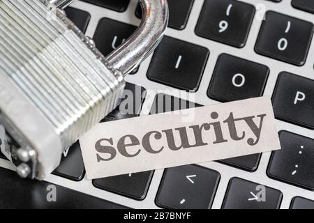 Computer-cyber security concept with padlock and computer keyboard with newspaper clipping of security Stock Photo