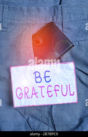 Text sign showing Be Grateful. Business photo text feeling or showing an appreciation for something received Small little wallet inside man trousers f Stock Photo