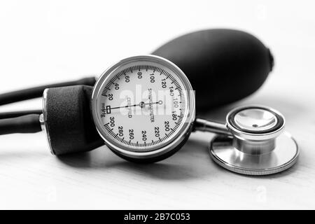 Blood pressure - A sphygmomanometer (an instrument for measuring blood pressure) on a white wooden desktop. Stock Photo