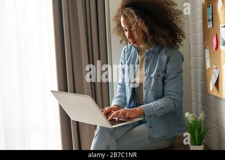 African american teen girl using modern laptop at home. Stock Photo