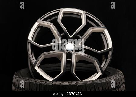 aluminum alloy wheel. Premium cast, the design of the spokes and the wheel rim, a white and black elements on dark background close-up. Stock Photo