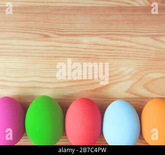 Row of Colorful Easter Eggs on Wooden Background with Copy Space Stock Photo