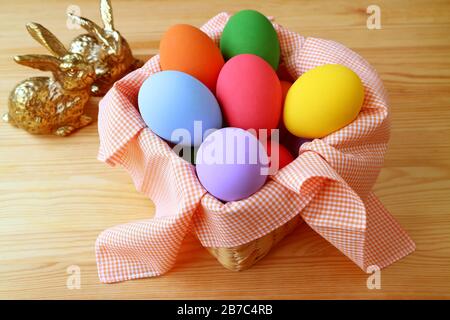 Basket of Colorful Easter Eggs with Blurry Two Little Bunnies in the Backdrop Stock Photo