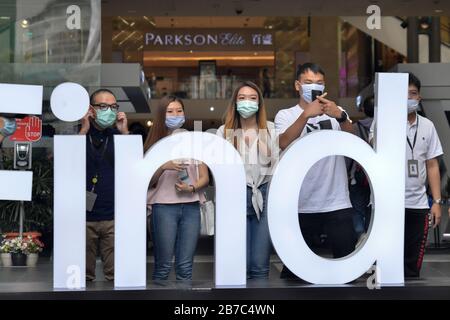 Beijing, Malaysia. 14th Mar, 2020. People wearing masks pose for photos on a street in Kuala Lumpur, Malaysia, March 14, 2020. Malaysia on Saturday announced 41 new cases of COVID-19, bringing the total number in the country to 238. Credit: Chong Voon Chung/Xinhua/Alamy Live News Stock Photo