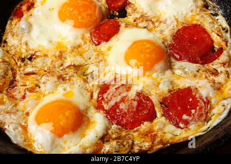 Fried eggs with tomatoes in a frying pan Stock Photo