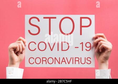Woman's hands holding poster with text Stop Coronavirus. Stock Photo