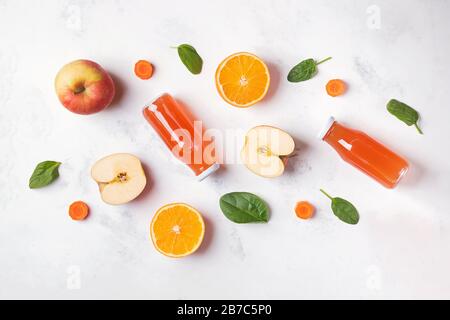 Healthy fruit juices, apples and oranges on white table, top view. Stock Photo