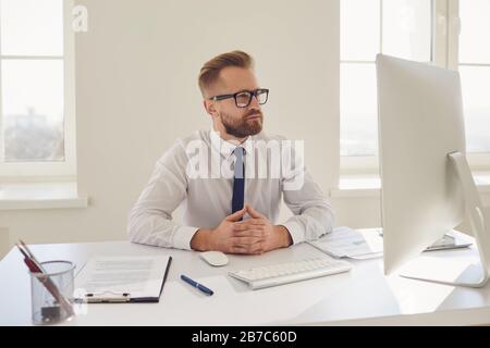 Serious busy businessman working sitting at a table with a computer in the office. Stock Photo