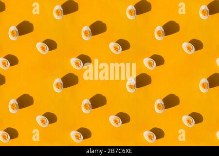 Boiled eggs cut in half on yellow background, flat lay. Stock Photo