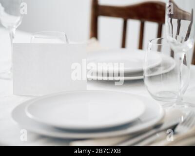 Beautiful table setting in white colors. Empty white plates. Set table for romantic dinner for two at home Stock Photo