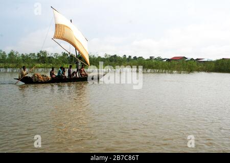 A traditional boat with sail in brahmaputra river in Gaibandha, Bangladesh.  Due to improved mechanical system, manual boat is very rare. Stock Photo