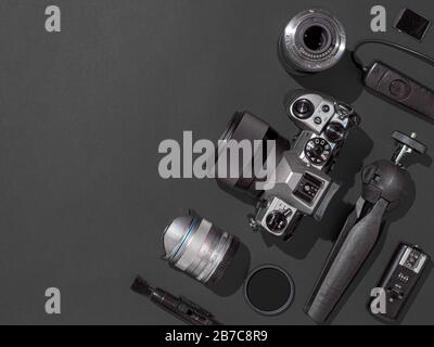 Photographer workplace with dslr camera, lens, pen tablet and camera accessories on black background. Camera, photography, visual content concept. Flat lay or top view. Copy space. Hard light. Stock Photo