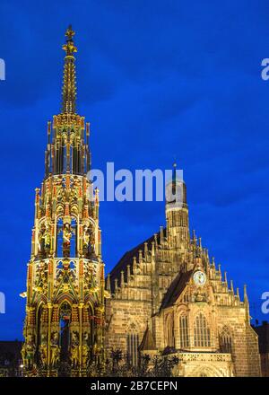 The Schöner Brunnen and Frauenkirche at night in Nuremberg. Stock Photo