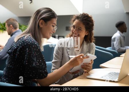 Happy diverse colleagues having fun, working on project together Stock Photo