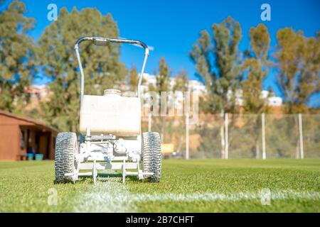 Lining a football pitch using white paint on grass Stock Photo