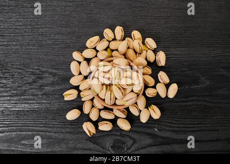 pistachios in a bowl on black wooden background Stock Photo