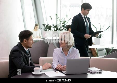 Diverse businesspeople discuss partnership collaborating at briefing Stock Photo