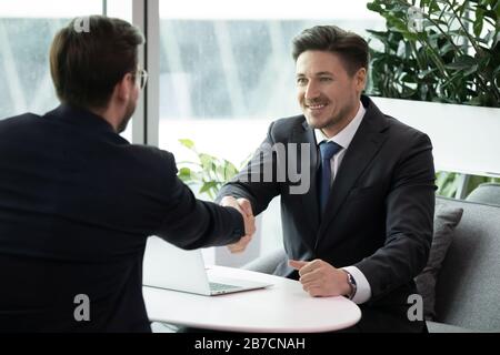 Smiling businessmen handshake closing deal after meeting Stock Photo