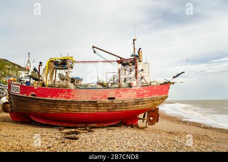 Red fishing boat on the beach in Hastings on a grey winter day Stock Photo