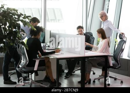 Diverse colleagues busy working in shared office space Stock Photo