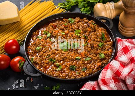 Bolognese sause in iron plate at black table. Stock Photo