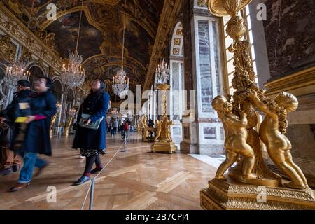 Detail of gilded sculptures on the foot of a candelabrum at the Hall of Mirrors ballroom at the Palace of Versailles in the outskirts of Paris, France Stock Photo