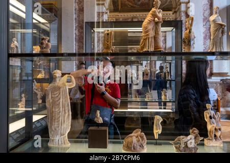 Tourist taking pictures of sculptures at the Louvre Museum in Paris, France, Europe Stock Photo