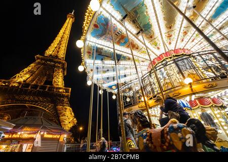 Nighttime view of the old classic carousel outside the Eiffel Tower in Paris, France, Europe Stock Photo