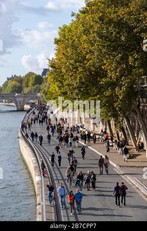 Pedestrians walking along the Seine river quayside in Paris, France, Europe Stock Photo