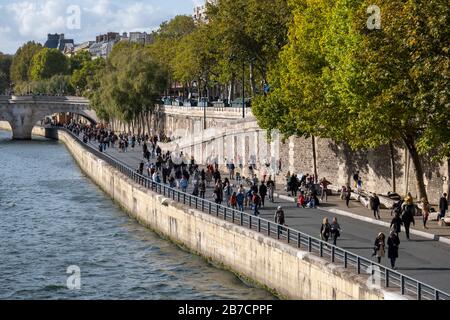 Pedestrians walking along the Seine river quayside in Paris, France, Europe Stock Photo